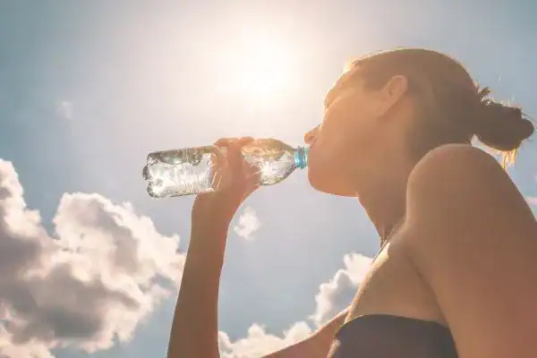Hydration: The Secret Ingredient for a Toned Stomach and Enhanced Fitness 3 Image of woman drinking water to hydrate Wellingborough after run.