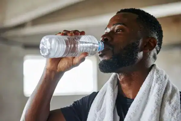 Hydration: The Secret Ingredient for a Toned Stomach and Enhanced Fitness 1 Image of man drinking water to improve hydration Wellingborough after work out.
